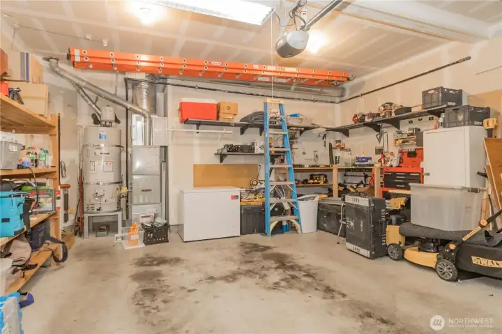 Furnace and hot water heater in garage. All shelves will stay
