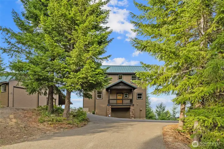 An enchanting front approach leads to a large paved driveway with plenty of parking for guests, trailers, RVs, and all your recreational toys!