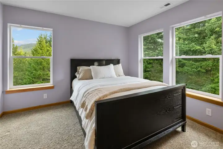 This guest bedroom enjoys beautiful mountain and territorial views, creating a bright and welcoming space for overnight guests.