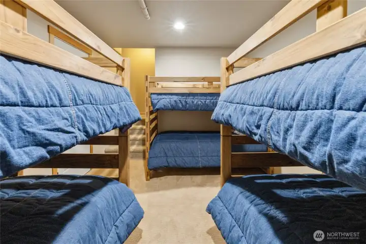 The lower-level bonus room offers exceptional flexibility, currently configured as a bunk room with sleeping space for six.