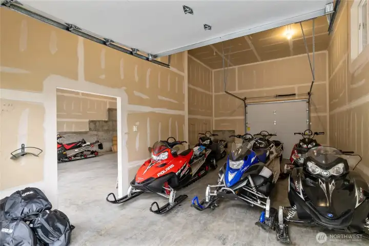 The secondary bay features a convenient pull-through design and offers storage for approximately eight snowmobiles, making it ideal for year-round mountain recreation.