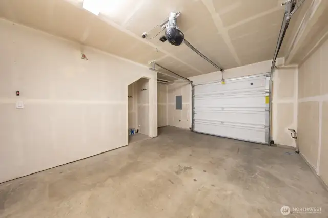 Spacious attached garage with storage alcove.