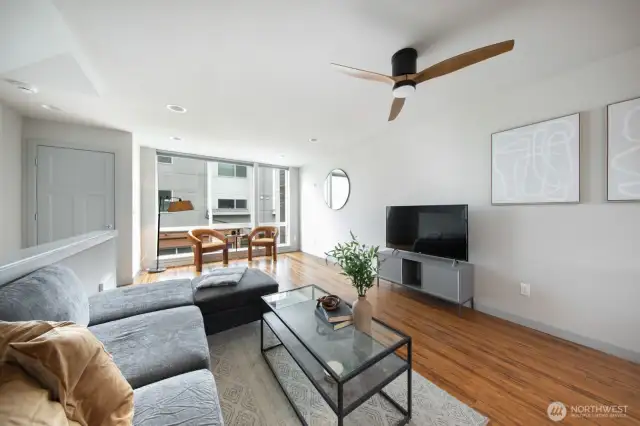 Spacious living room with floor-to-ceiling windows, offering abundant natural light.