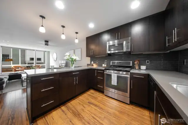 Functional U-shaped kitchen with plenty of storage opens to the main living area.