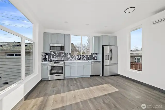 This open space  kitchen, living, and dining room showcases the lay out and high-quality finishes you can expect in the newly constructed home at 8612 A, B, & C-42nd Ave S, Seattle, WA 98118, built by the same builder.