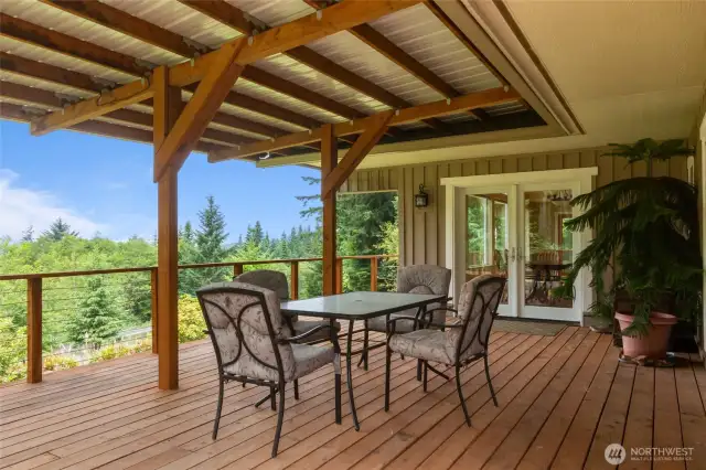 Perfect for outdoor meals or simply relaxing, this covered deck offers a serene space to unwind while taking in the natural beauty surrounding the home.