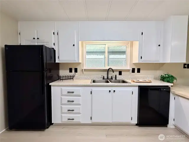 Other side of the kitchen with new refrigerator, new sink and faucet, and new dishwasher.