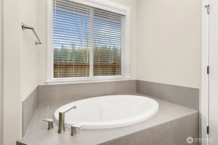 Large soaking tub with tile deck, perfect for holding all the bath supplies