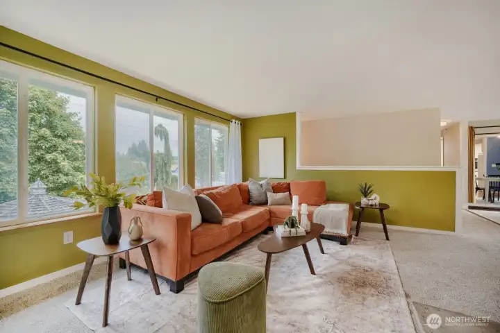 Wall of windows in the living room brings bright natural light in! Pony wall is open to the stairs to the lower level.