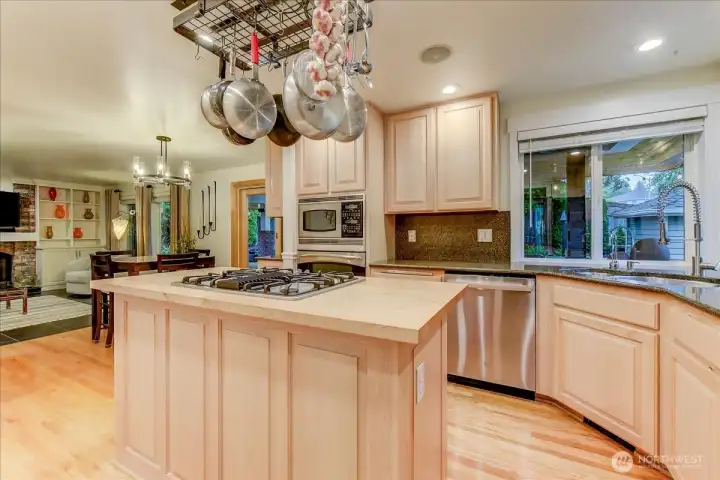 Spacious kitchen featuring solid wood cabinetry, a butcher block kitchen island, and a gas cooktop.