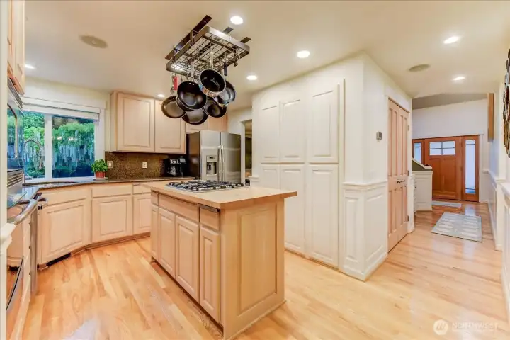 Spacious kitchen featuring abundant storage, a large pantry, and expansive, bright windows that overlook the beautifully landscaped yard.