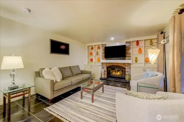 Bright and spacious family room featuring a cozy gas fireplace and custom built-in cabinetry.