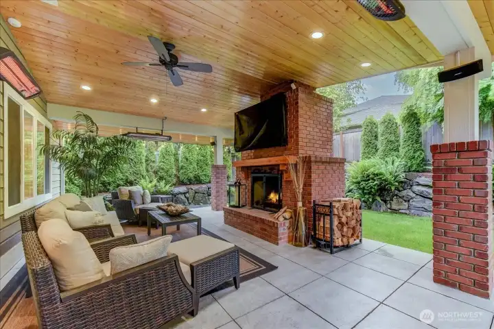 65" TV stays and is mounted above a dual-fuel fireplace featuring a decorative mantle; currently configured for wood-burning with the wood and holder included.