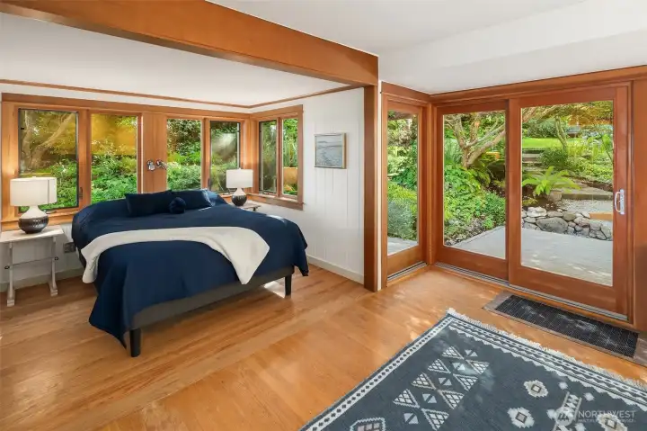 The spacious primary bedroom rests on the main level of the home and has a private entrance to the back deck. The spacious primary bedroom rests on the main level of the home and has a private entrance to the back deck.
