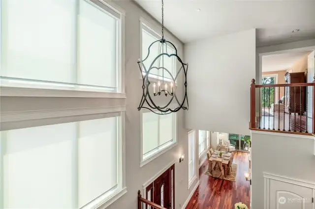 Bird's eye view of the pretty chandelier and great height over formal staircase.