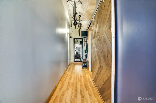 The private bedroom has this incredible sliding barn door that provides privacy from guest who enter through the front door. Notice the creative storage in the hallway too!