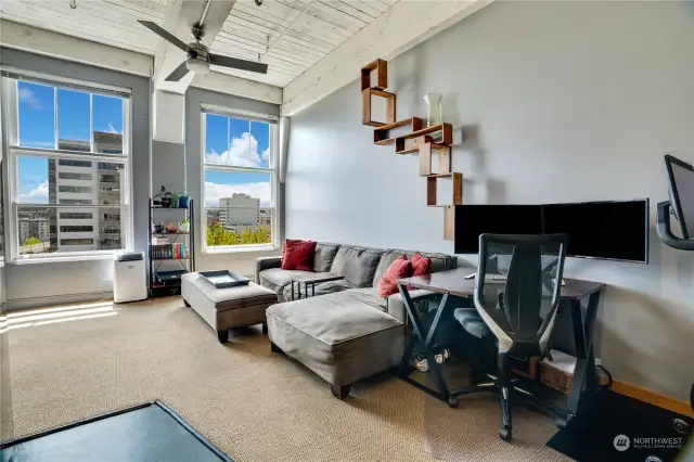 The living room boasts floor to ceiling windows welcoming abundant natural light, scenic outlooks of the cityscape and waterway, and views of Mt. Rainier.