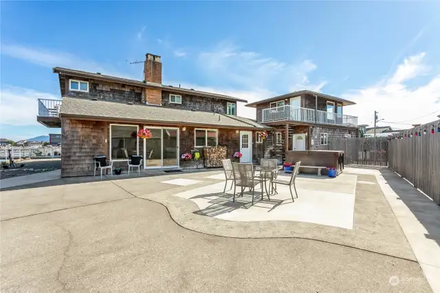 A view of the side patio with hot tub. The sliders open from the kitchen and dining area. The bonus room is up the spiral staircase and located above the garage.