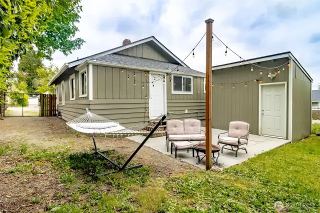 Your own private getaway — string lights, comfy seating, and a hammock under the trees make this patio a dream come true for relaxing evenings under the stars.