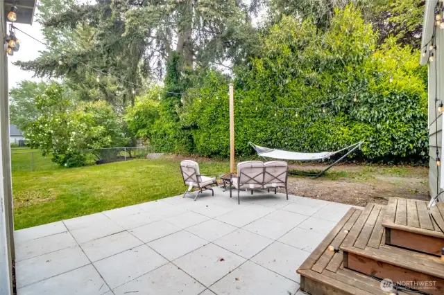 Tall hedges and mature trees create a peaceful, secluded vibe — perfect for quiet mornings with coffee or cozy nights by the firepit.