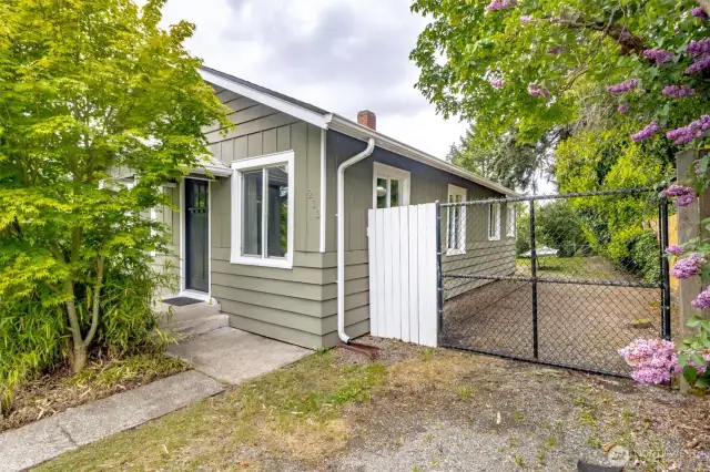 Fully fenced in back yard with car length gate providing drive in access