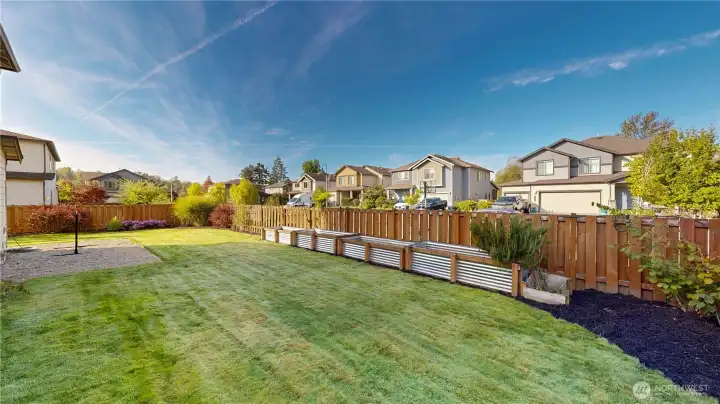 Fully fenced backyard with raised garden beds