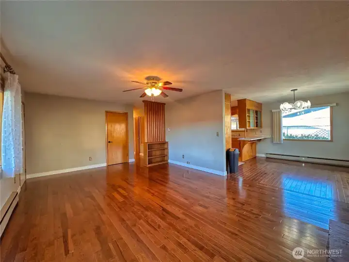 Hardwood flooring extends into the dining room and hallway