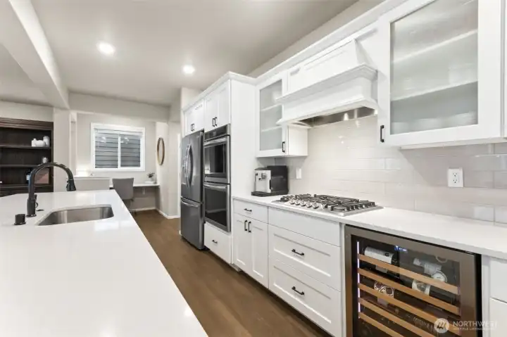 The light-filled kitchen shines as the heart of the home, where expansive windows and an open layout create an airy, welcoming atmosphere. A work station/nook just off of the kitchen is a wonderful flex space for a variety of uses.