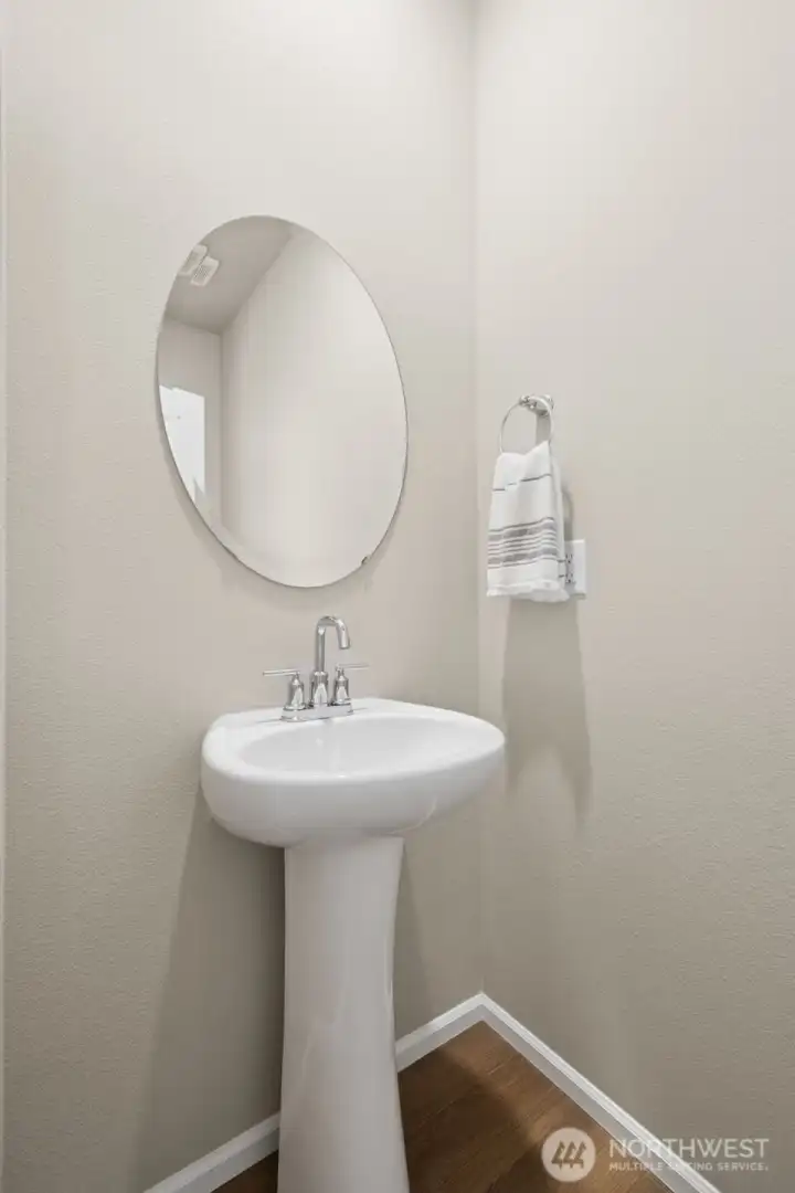 A conveniently located main floor half bath offers comfort and practicality for guests. Thoughtfully positioned away from the main living areas, it provides privacy while remaining easily accessible.