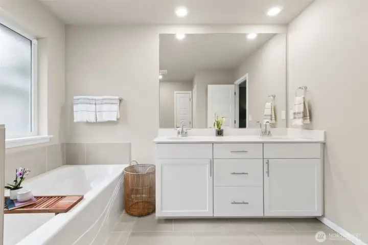 Relax and recharge in the spa-like owner’s bath. Elegant details and ample space create a calming escape.