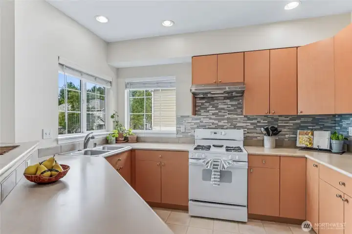 A gas cooktop delights the home chef, while extra windows flood the kitchen with natural light, creating a bright and inviting space.