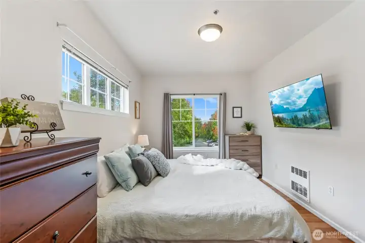 The primary bedroom offers a stunning view of the tree-lined lane. Double windows brings in extra sunshine.