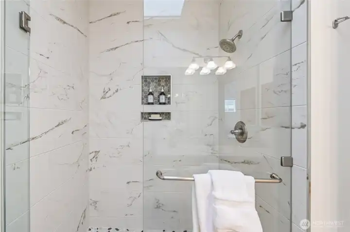 This oversized, updated primary shower features elegant designer touches for a spa-like experience.