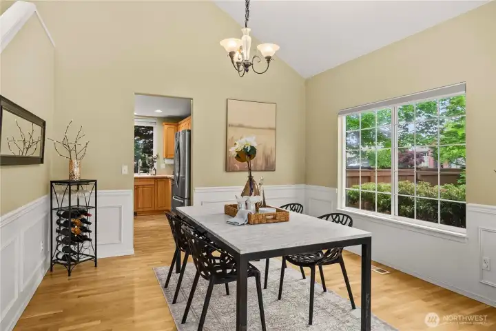 Another view of the dining room showcasing the large window and beautiful natural light, with plenty of space to gather around the table.