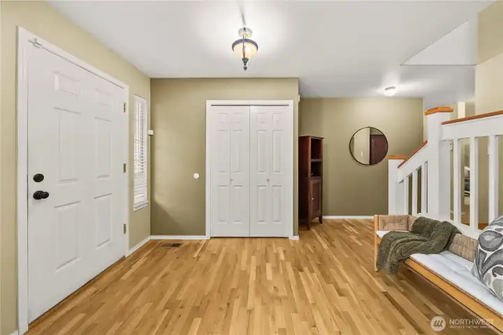 Welcoming entryway featuring beautiful hardwood floors and a conveniently located coat closet.