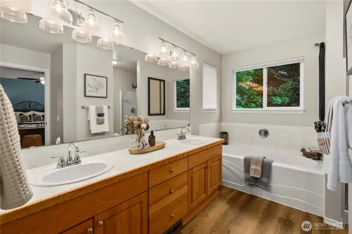 View of the primary ensuite showcasing the spacious dual vanity and large soaking tub.