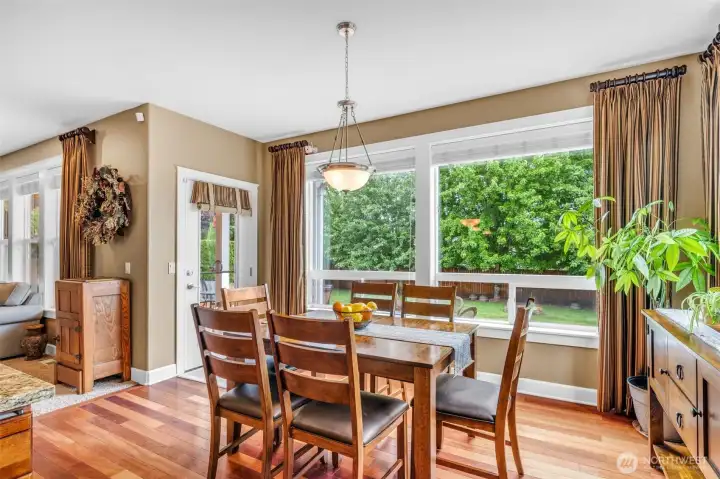 Bright dining nook surrounded by large windows overlooking the backyard, creating the perfect setting for casual meals, morning coffee, or gathering Bright dining nook surrounded by large windows overlooking the backyard, creating the perfect setting for casual meals, morning coffee, or gathering