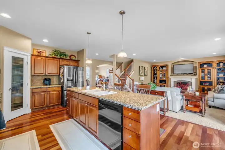 Open-concept kitchen featuring granite countertops, a large center island with eating bar, abundant cabinetry, and a layout designed for both cooking and entertaining. Open-concept kitchen featuring granite countertops, a large center island with eating bar, abundant cabinetry, and a layout designed for both cooking and entertaining.