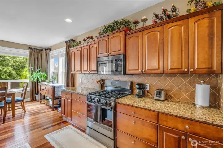 Chef-inspired kitchen with extensive counter space, rich wood cabinetry, granite surfaces, and a convenient walk-in pantry for additional storage. Chef-inspired kitchen with extensive counter space, rich wood cabinetry, granite surfaces, and a convenient walk-in pantry for additional storage.