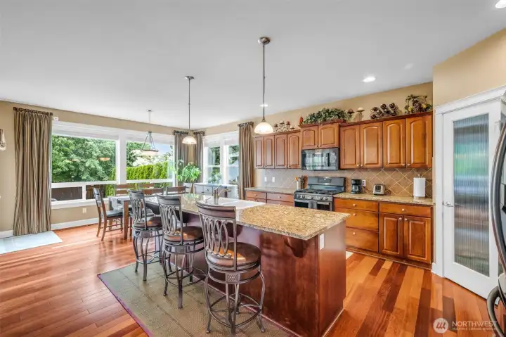 The heart of the home, offering a large island, hardwood floors, recessed lighting, and an open flow to the living and dining spaces. The heart of the home, offering a large island, hardwood floors, recessed lighting, and an open flow to the living and dining spaces.