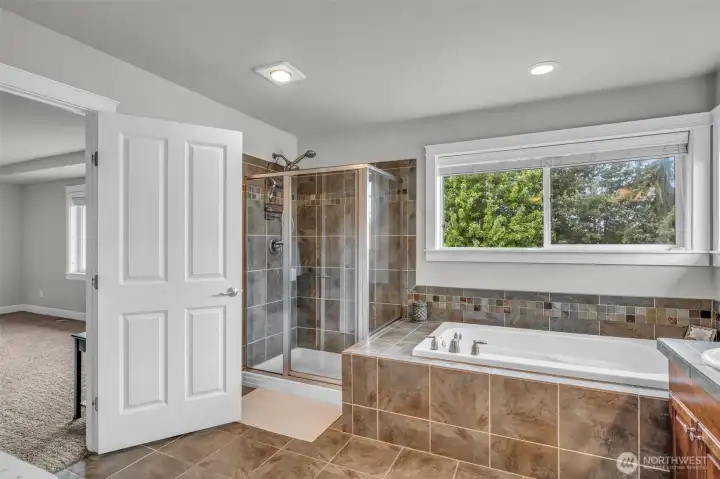 Spa-inspired primary bath featuring a tiled walk-in shower, soaking tub, generous counter space, and a bright, open design perfect for everyday comfort. Spa-inspired primary bath featuring a tiled walk-in shower, soaking tub, generous counter space, and a bright, open design perfect for everyday comfort.