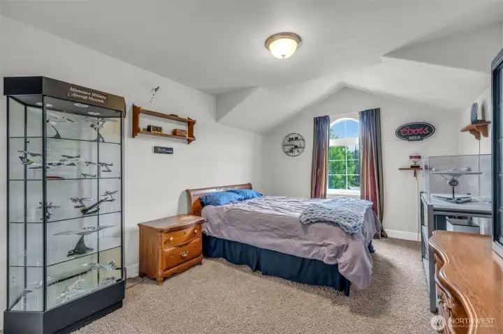 Spacious bedroom featuring vaulted ceilings, large windows, and room for a sitting area or additional furnishings. Spacious bedroom featuring vaulted ceilings, large windows, and room for a sitting area or additional furnishings.