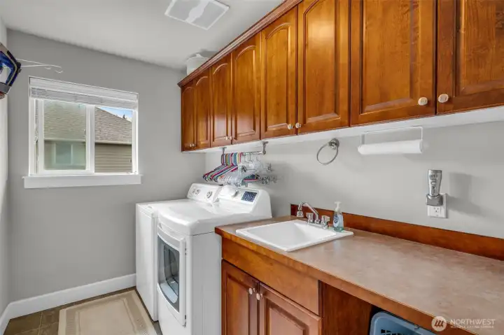 Convenient upstairs laundry room with built-in cabinetry, utility sink, and abundant storage. Convenient upstairs laundry room with built-in cabinetry, utility sink, and abundant storage.