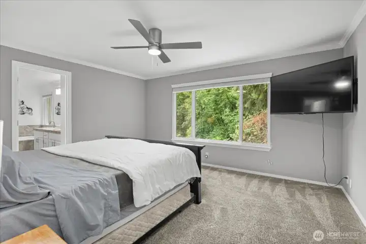 Primary bedroom windows looks out to green space.