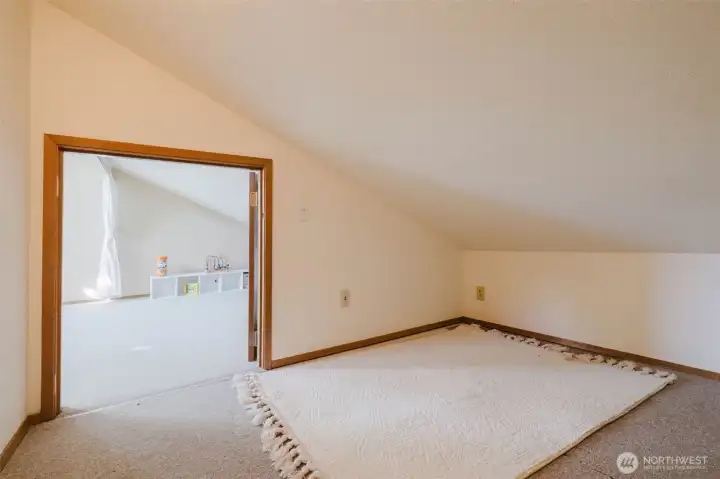 Bigger than it looks, brighter than you'd expect. The angled ceiling and open doorway to the loft keep this space from ever feeling closed in — just cozy. Plenty of room for a twin bed, a toy chest, a pile of holiday bins, or whatever your imagination lands on first.
