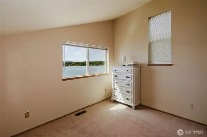 Wake up to water. The angled ceiling lifts the room, the windows pull in the light, and one of them frames exactly the view you moved here for. There's even a built-in dresser already waiting — because a room this good deserves to be lived in, not just admired. This is the one you'll fight your partner for.