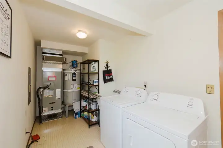 The laundry room that actually has it all together. Tucked conveniently on the main floor, this generous laundry room is one of those practical spaces that makes everyday life just a little bit easier. The full-size washer and dryer are included — just move in and get on with living. But this room works harder than most. The 1-year-old hot water tank and the heat pump system are housed right here, neatly accessible and well maintained — major mechanicals that give you complete peace of mind from day one.