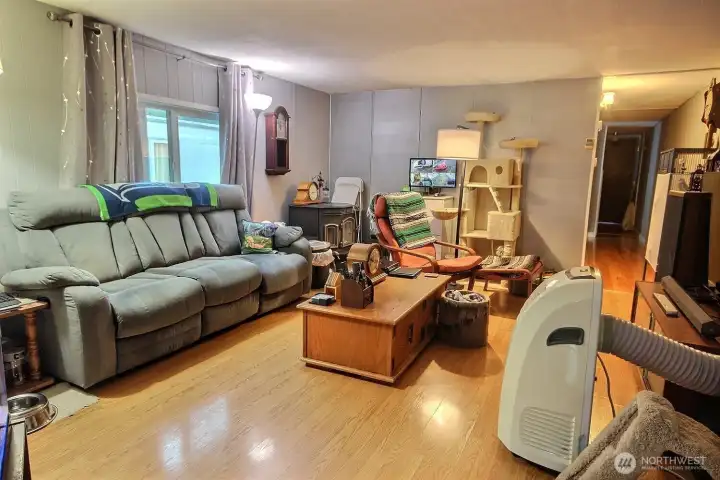 Living room with natural light, laminate flooring, and functional everyday layout. Living room with natural light, laminate flooring, and functional everyday layout.