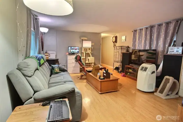 Living room with natural light, laminate flooring, and functional everyday layout. Living room with natural light, laminate flooring, and functional everyday layout.