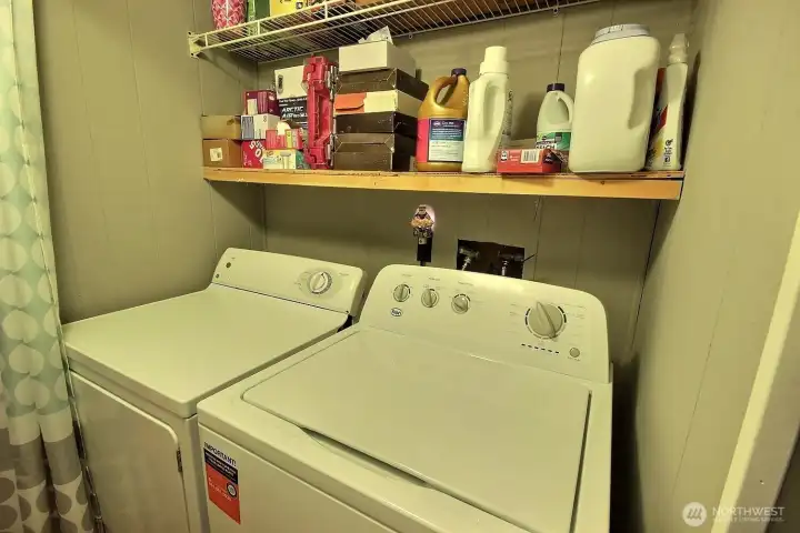 Laundry area with washer, dryer, and overhead shelf storage for everyday convenience. Laundry area with washer, dryer, and overhead shelf storage for everyday convenience.